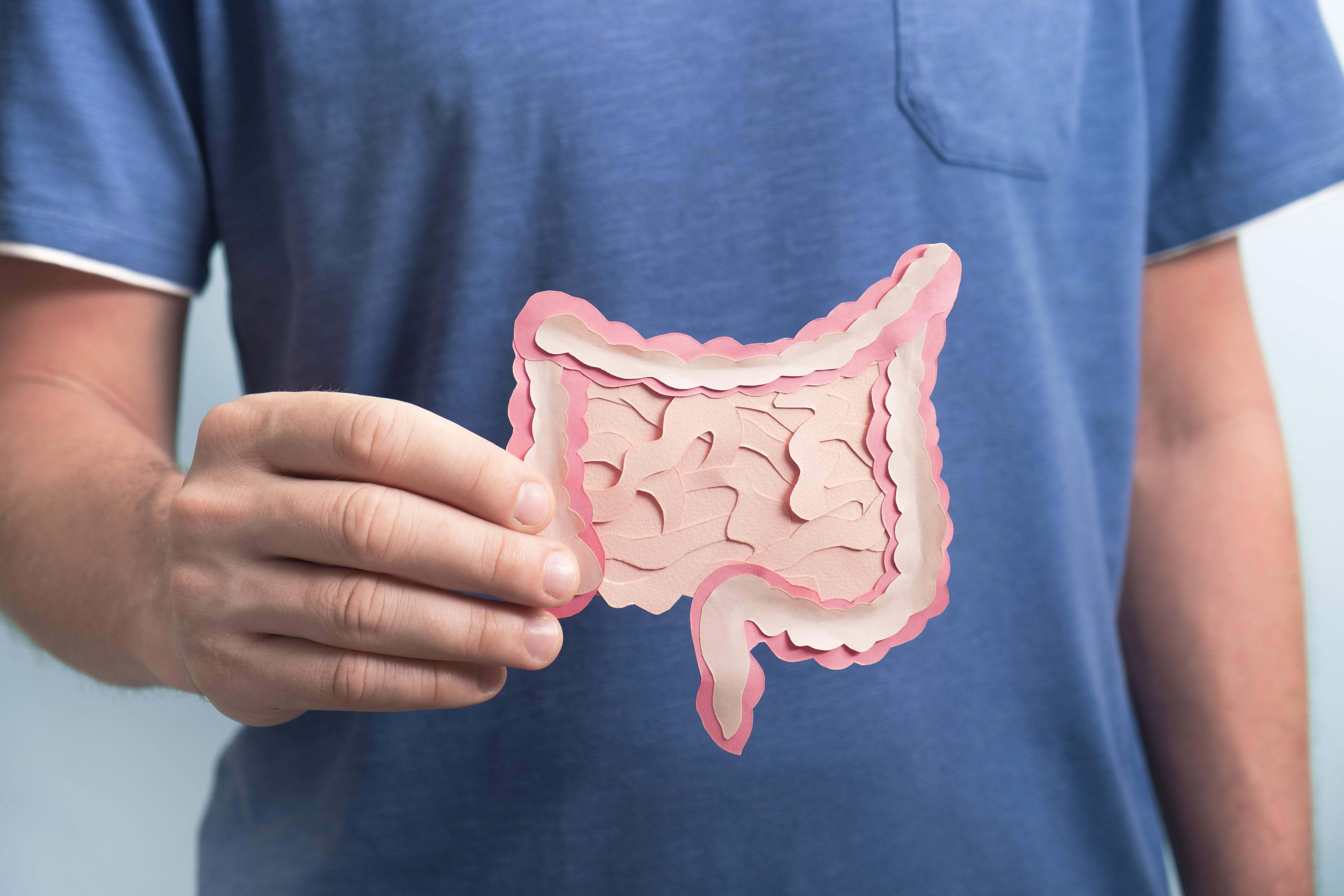 Man holding paper cutout of colon